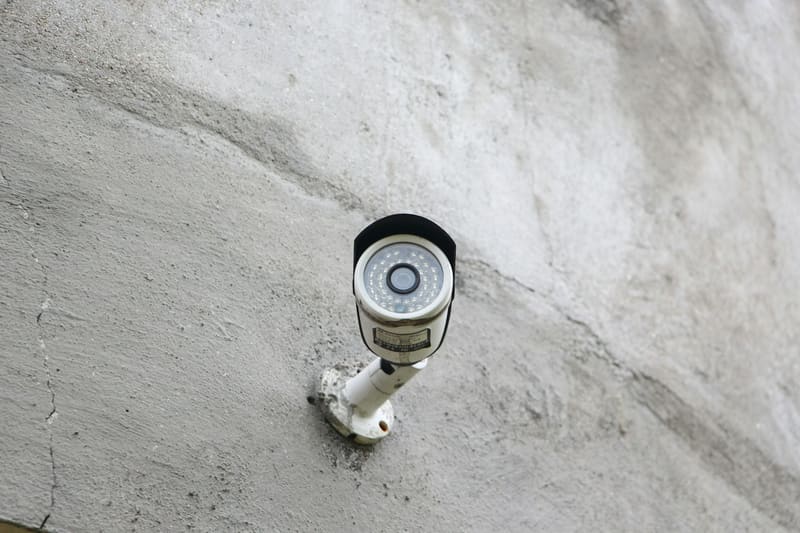 A security camera mounted on a concrete wall